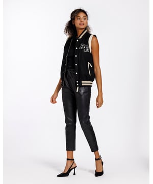 Een varsity gilet van hoge kwaliteit. Een moderne klassieker die altijd in stijl blijft. De jas is gemaakt van schapenwol. Aan beide zijden zitten ritszakken. De ritssluiting aan de voorkant van het jack kan worden gesloten met drukknopen.
