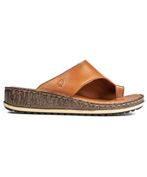 Relájate y dale la bienvenida al día con estos cómodos. Sandalias de cuero de Hush Puppies. Esta chancla de verano presenta una parte superior color canela suave con una tira para el dedo y un diseño de correa ancha para un ajuste cómodo. Con un cómodo. Plantilla acolchada y suela adherente con tacón de cuña. Diviértete bajo el sol. descansa en casa o realiza tus tareas domésticas con estas versátiles sandalias.
