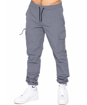 Desata el poder del estilo y la funcionalidad con nuestros pantalones de tecnología de poliéster de primera calidad. Con un diseño de pierna recta y ajuste regular, estos pantalones presentan un tobillo ajustado con un cierre de cordón y una cintura elástica con cordón ajustable. No pases por alto la comodidad de los dos bolsillos laterales con cremallera, el bolsillo trasero con ribete y los dos bolsillos exteriores tipo cargo. Eleva tu vestuario con este conjunto exclusivo y elegante.