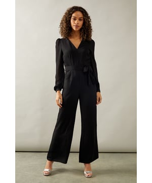 Elegant wide-leg jumpsuit for sophisticated occasions
        Flattering V-neckline enhances the dcolletage
        Chiffon sleeves add a touch of romance and movement
        Cinched waist with tie detail for a feminine silhouette
        Versatile design suitable for various formal events
    
    Make a striking entrance at your next formal occasion with this chic wide-leg jumpsuit from Wallis. The flowing silhouette combines comfort with glamour, perfect for the woman who appreciates sophistication without compromising on ease. The V-neckline frames your face beautifully, while the chiffon sleeves add a delicate, ethereal touch to the ensemble. The cinched waist with its tie detail creates a flattering shape, accentuating your figure. Style this versatile piece with strappy heels and statement earrings for a wedding or pair it with a sleek clutch and elegant updo for a black-tie event. The jumpsuit's adaptable nature makes it an ideal choice for various formal gatherings, from cocktail parties to evening galas. Its timeless design ensures you'll reach for this wardrobe staple time and again, making it a worthy investment for your occasion wear collection.