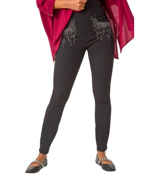 Hotfix Pocket Jegging from Roman. Add some sparkle to your denim collection with these embellished hotfix pocket jeggings. Crafted from a comfortable stretch denim fabric, these jeggings feature a pull-on style for ease and comfort. The standout hotfix pocket trim detail adds a touch of glamour to your casual look. Perfect for the Autumn/Winter season, style these jeggings with knitwear and trainers for a chic and cosy outfit!