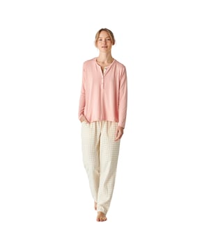 Pijama de mujer de manga larga con un diseño elegante y cómodo, ideal para descansar o relajarse en casa.

Su diseño moderno y sofisticado se adapta perfectamente a la figura femenina, realzando la silueta con un estilo chic y relajado.

El conjunto incluye una parte superior de manga larga que presenta un cuello redondo y una pequeña botonadura en la parte frontal, que aporta practicidad y un toque de estilo. 

El pantalón largo tiene un ajuste holgado y una cintura elástica ajustable mediante cordones con un elegante estampado a cuadros.

Esta pijama está diseñada para brindar máxima comodidad durante el descanso.

Confeccionada en materiales ligeros y suaves, es perfecta para cualquier época del año.
 Composición: Camiseta: 95% Modal, 5% Elastano; Pantalón: 100% Algodón
 Cuidados:
-Lavado a máquina en frío y en ciclo suave para evitar el desgaste de las fibras.
-No usar lejía o blanqueadores
-Secar al aire libre o en secadora a baja temperatura para evitar que se encoja o pierda su forma.
-Planchar a temperaturas bajas.