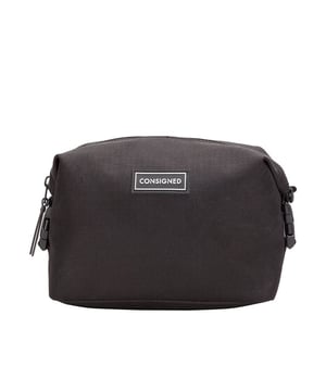 The Ellis Wash Bag, an essential cosmetic companion is made of RE-CONSIGNED outer fabric, produced from 100% recycled plastic bottles - Global Recycled Standard certified fabric. A double clip feature allows multi-functional use, enabling the bag to transform into 3 different designs depending on your needs. It’s all in the detail with a specialist waterproof zip providing easy access to the main compartment. The interior features our wipe clean microfibre lining with double slip pockets and a large central compartment for all your essential cosmetic needs. Features: , RE-CONSIGNED ripstop outer fabric made from 100% recycled plastic bottles - Global Recycled Standard certified fabric, 4 Plastic bottles saved from landfill in the production of this product, 4 Litre internal capacity, Water Resistant, Double clip feature which allows the bag to be styled 3 different ways, Waterproof zip top opening to main compartment, 2 Internal slip pockets, CONSIGNED seal of approval rubberised patch logo, RE-CONSIGNED seal of approval rubberised patch logo, CONSIGNED branded webbing, Microfibre easy wipe clean lining, Rubberised zip pullers, Small model Style Ref: 50527 BLACK