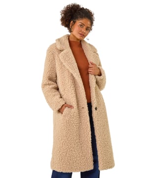 Dusk Borg Detail Longline Coat from Roman. Wrap up in style this Winter with this full-length Borg coat in classic biege. The soft Borg fabric provides ultimate warmth while the button detailing adds a touch of sophistication. Perfect for chilly days, this coat is ideal for layering over your favourite knitwear and jeans for a chic and cosy look that will keep you stylishly warm all season long!