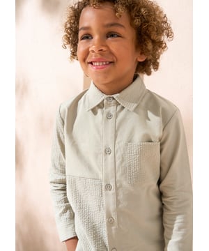 An A&R twist on the classic shirt. A clever mix of cut and sew textured and plain panels in soft sage green. this long-sleeved shirt features a classic silhouette and a button placket. A versatile piece that can be dressed with chinos or shorts and worn w.