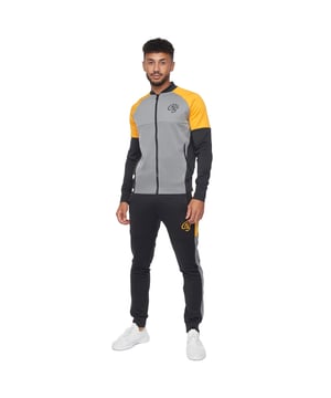 Stof: Zachte aanraking, Stretch. Ontwerp: Kleurenblok, Logo. Zakken: 2 Voorzakken, 2 Zijzakken. Hals: Crew Neck. Manchet: Elastiek. Mouwtype: Met lange mouwen. Zoom: Gedeeltelijk Elastisch. Stoftechnologie: Ademend. Geboeide enkel. Sluiting: Rits vooraan, Pull-On. Inhoud: 1 broekje, 1 jasje. Pasvorm: Relaxed model. S: 38 in. M: 40 in. L: 42 in. XL: 44 in.
