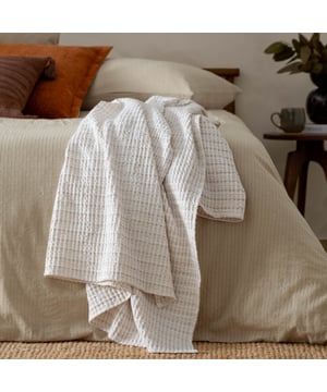 Add effortless style your bedroom with the Waffle Textured Bedspread, designed for a classic minimalist look. Made from 100% soft cotton, this lightweight bedspread combines comfort with a waffle textured pattern and subtly woven yarn-dyed stripes, adding a hint of colour. Its double-sided design makes styling easy - drape it loosely for a relaxed, modern vibe or lay it neatly for a classic, understated finish. Perfect for those seeking a touch of texture and a relaxed space. 140 x 220cm