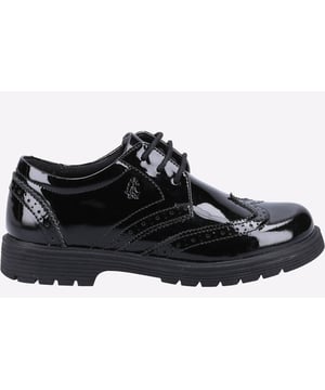 Zapatos Hush Puppies Sally negros para niña, fabricados en piel y suela de goma. Presentan acabado charol, suela de goma con tacos, plantilla cómoda y horma estándar.