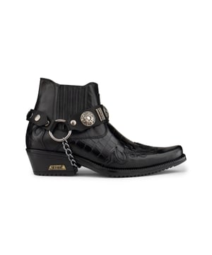 El winklepicker es un estilo popular de botas, usado desde la década de 1950 y un favorito entre los artistas británicos de rock and roll a lo largo del tiempo. Este par se completa con la característica distintiva del winklepicker, que es la punta afilada, así como la silueta tradicional de botín y un tacón cubano vintage de 2". Esta pieza se caracteriza por la introducción de una elegante textura de piel de cocodrilo, así como diseños de paneles cosidos en la puntera y el talón y un diseño con volantes en los laterales. Esta bota se completa con la incorporación de una característica de correa de triple arnés, que está conectada por un anillo de metal y presenta insignias metálicas y tachuelas para crear una estética llamativa. • Elaborado con cuero de vaca genuino con textura de piel de cocodrilo • Presenta una distintiva punta puntiaguda, un tacón cubano de 2" y una caña alta hasta el tobillo • Característica de correa metálica de triple arnés • Marca ETOR adornada en la suela