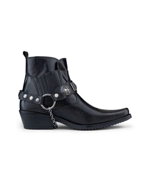 El winklepicker es un estilo popular de botas, usado desde la década de 1950 y un favorito entre los artistas británicos de rock and roll a lo largo del tiempo. Este par se completa con la característica distintiva del winklepicker, que es la punta afilada, así como la silueta tradicional de botín y un tacón cubano vintage de 2". Este zapato se caracteriza por una textura fina que está intrincadamente diseñada en la parte superior del zapato, con diseños de paneles cosidos adicionales en la punta y el talón, así como un diseño con volantes en los lados. Esta bota se completa con la adición de una característica de correa de arnés triple, que está conectada por un anillo de metal y presenta insignias metálicas y tachuelas para crear una estética llamativa. • Elaborado con cuero de vaca genuino • Presenta una distintiva punta puntiaguda, un tacón cubano de 2" y una caña alta hasta el tobillo • Característica de correa metálica de arnés triple • Marca ETOR adornada en la suela