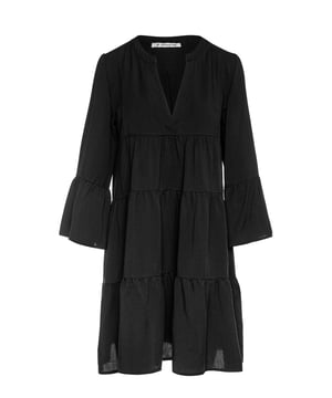 Vestido negro con costuras fruncidas en tejido de tencel tejido. Mangas acampanadas 3/4. Escote redondo con una abertura en V de 24 cm en la parte delantera. Broche a presión en el interior en la parte inferior de la V para evitar que se abra demasiado. Doble capa de forma oblonga debajo de la abertura en V en la parte delantera. El vestido tiene dos paneles fruncidos de 24 cm de ancho. Pliegue doble en la parte posterior. Silueta suelta en línea A. Largo por encima de la rodilla.