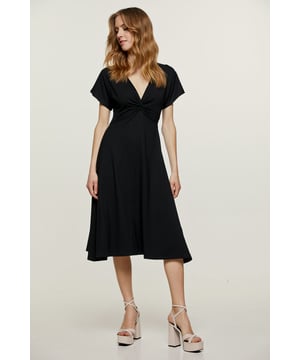 Dieses schwarze Sommerkleid ist aus Stretch-Jersey-Stoff gefertigt. Es hat kurze Ärmel und einen V-Ausschnitt mit Knotendetail an der Brust. Darunter schließt ein 5 cm breiter Besatz diagonal an den Seiten. Der Rock hat eine Glockensilhouette. Das Kleid ist in einer entspannten Passform und Midi-Länge gestaltet.