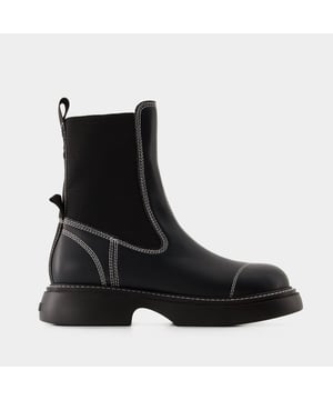 Las botas Everyday Mid Chelsea Boots de Ganni son una opción de calzado moderna y versátil, con un diseño clásico de bota Chelsea con un toque contemporáneo. Para complementar su elegante silueta y su estilo práctico, combínalas con conjuntos a la moda y funcionales. Considera la posibilidad de llevarlas con un vestido floral de largo medio y una cazadora vaquera para un look chic sin esfuerzo, o con unos pantalones cortos y un jersey oversize para un conjunto más informal pero sofisticado. Estas opciones ponen de relieve el atractivo minimalista de las botas y el talento de Ganni para crear piezas elegantes y fáciles de llevar, creando un look cohesionado y llamativo. Ideales para el día a día, la oficina o las salidas de fin de semana, este par ilustra la versatilidad de las Everyday Mid Chelsea Boots y su capacidad para añadir un toque de discreta elegancia y estilo escandinavo a una gran variedad de conjuntos contemporáneos. Colores: Negro. Material principal: poliuretano. Material de la suela: cuero. Cierre: fácil de poner. Forma de la punta: redonda. Ajuste: fiel a la talla - Tallaje: americano.