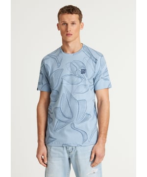 Das Wild ist ein Regular-Fit-T-Shirt mit einem Allover-Blumenmuster. Hergestellt aus Interlock-Baumwolle und versehen mit charakteristischen CHASIN'-Details.