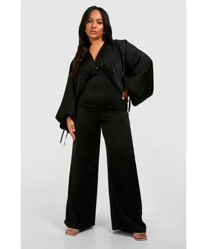 Luxurious matte satin fabric for a sophisticated look
        Flattering V-neckline with ruffle detail
        Dramatic wide-leg silhouette for a statement look
        Voluminous balloon sleeves with tie cuffs
        Cinched waist design to accentuate your figure
    
    Make a bold entrance in this striking plus-size jumpsuit from Boohoo. Perfect for those unforgettable nights out, this all-in-one ensemble combines comfort with high fashion. The matte satin fabric drapes beautifully, creating a sleek silhouette that's both elegant and eye-catching. The wide-leg trousers offer a dramatic flair, while the cinched waist flatters your curves. Style it with strappy metallic heels and statement earrings for a head-turning look at the club. For a more relaxed vibe when meeting friends at the bar, pair it with trendy trainers and a leather jacket. The versatile design allows for easy transition from day to night, making it a must-have piece for the fashion-forward woman who values both style and practicality.