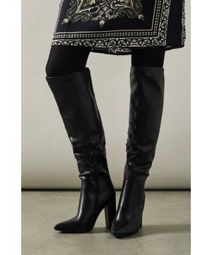 Over-the-knee design for a bold, statement look
        Pointed toe shape adds a touch of sophistication
        High block heel between 7-9cm for a confident stride
        Faux leather material offers a sleek, polished appearance
        Versatile style suitable for various daywear occasions
    
    Step out in style with these striking Kandi over-the-knee boots from Oasis. The sleek faux leather finish and pointed toe design lend a touch of elegance to any ensemble. With a comfortable yet eye-catching high block heel, these boots are perfect for adding a dash of drama to your daytime look. Pair them with a flowy printed dress for a chic contrast, or team with skinny jeans and an oversized jumper for a more casual vibe. Ideal for family gatherings, brunches with friends, or a day out shopping, these versatile boots will quickly become your go-to footwear for elevating everyday outfits. The over-the-knee silhouette offers warmth and style in equal measure, making them a practical choice for cooler days without compromising on fashion-forward appeal.