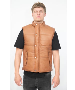 Diese Weste ist aus unserem hochwertigen Vollnarben-Nappaleder gefertigt, was zu einer glatten Oberfläche führt, die gut zu den polierten Metalldruckknöpfen passt, mit denen die Jacke befestigt wird. Wir verfügen über zwei schräge vertikale Pattentaschen an der Taille, die dieser ansonsten schlichten Vorderseite zusätzliches Flair verleihen und zur sicheren Aufbewahrung geknöpft werden können. Diese Jacke ist im Puffer-Stil für zusätzliche Isolierung bei kälterem Wetter gefertigt und in den Premiumfarben Schwarz, Braun und Hellbraun erhältlich. • Hergestellt aus ultraweichem Nappaleder. • Zwei vertikale Pattentaschen an der Taille. • Kurzer Stehkragen und geknöpfter Verschluss vorne