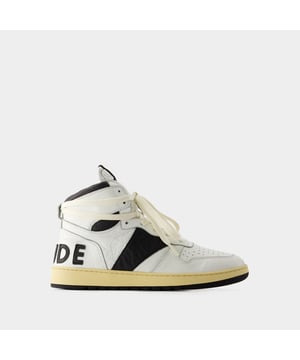 Presentamos las zapatillas Rhecess de Rhude, donde la frescura urbana se une a la comodidad contemporánea. Estas zapatillas fusionan a la perfección un diseño moderno con un guiño al estilo streetwear, mostrando una silueta única perfecta para ir a la moda statement. Para elevar tu look con estas zapatillas statement, considéralas la base de un conjunto moderno de inspiración callejera. Combínalas con unos vaqueros desgastados, una sudadera con capucha de estampado gráfico y unas gafas de sol atrevidas para conseguir un look vanguardista sin esfuerzo, perfecto para un día con amigos o una noche informal en la ciudad. Rhude Las zapatillas Rhecess de brand ejemplifican el compromiso de la marca con la calidad y la moda, ofreciéndote una opción de calzado distintiva y versátil que combina sin esfuerzo el encanto moderno con el estilo urbano. Sal con confianza, mostrando tu sensibilidad única por la moda y tu estilo de entrenador contemporáneo. Colores: Blanco - Blanco/Negro. Material principal: piel de ternero lisa. Material de la suela: caucho. Material del forro: algodón. Cierre: cordones en la parte superior. Forma de la punta: almendra. Ajuste: fiel a la talla - Talla: