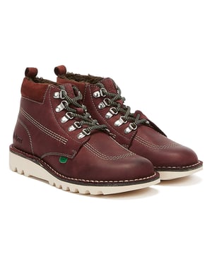 Esta bota clásica presenta el estilo icónico de Kickers, confeccionada con una parte superior de piel con triple costura, cuello acolchado y lengüeta con la marca, rematada con una suela gruesa.