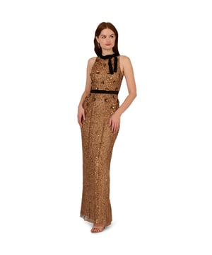 Make a bold and sparkling statement when you slip into this velvet and beaded gown. This formal dress features a halter bodice with velvet bow neckline, a velvet-trimmed waist, and a column skirt. Made with knit mesh and covered in decadent sequins and beading all over, this evening gown is trimmed with 3D sequin flowers. A hidden zipper closure at the centre back completes this column gown. A feminine look for a black-tie gala or formal attire wedding, this beaded dress will impress.