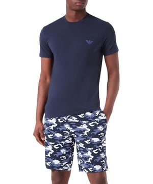 Pyjamaset voor heren bestaande uit een shirt met korte mouwen en een ronde hals en een bermuda met een decoratief patroon.