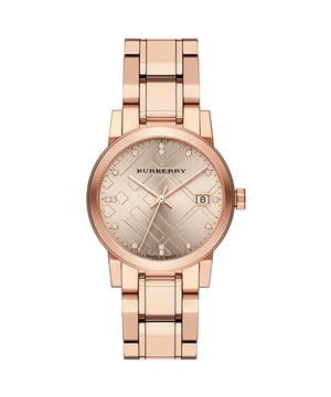 Produkt-Spezifikationen

Marke: Burberry  
Modell: BU9126  
Uhrwerk: Schweizer Quarz (Batterie)  
Gehäusegröße: 34 mm  
Gehäusematerial: Roségold PVD-beschichteter Edelstahl  

Armbandmaterial: Roségold PVD-beschichteter Edelstahl  
Zifferblattfarbe: Champagner-Zifferblatt mit Struktur  

Glas: Saphirglas  
Wasserdichtigkeit: 50 m oder 5 ATM  
Garantie: 2 Jahre internationale Garantie für Uhren  

Produktbeschreibung  
Wir präsentieren das Gefühl zeitloser Eleganz und Präzision – die Burberry Diamond Check Stamped Damenuhr. Dieses exquisite Zeitmessgerät verbindet nahtlos den ikonischen Burberry-Stil mit modernster Schweizer Handwerkskunst und schafft ein atemberaubendes Accessoire, das über Modetrends hinausgeht.  
Mit außergewöhnlicher Liebe zum Detail gefertigt, weist das Gehäuse dieser Uhr eine Größe von 34 mm auf, das zart mit luxuriösem roségoldenem PVD über Edelstahl beschichtet ist. Das Ergebnis ist eine harmonische Fusion aus Raffinesse und Langlebigkeit, die sicherstellt, dass Ihre Uhr so beständig bleibt wie das Erbe von Burberry selbst.  
Das in der Schweiz gefertigte Quarzwerk, betrieben von einer zuverlässigen Batterie, garantiert eine unübertroffene Genauigkeit und macht diese Uhr nicht nur zu einem Symbol für Stil, sondern auch zu einem Zeugnis präziser Zeitmessung. Das champagnerfarbene Zifferblatt, verziert mit einer ansprechenden Struktur, spiegelt das Engagement der Marke für Exzellenz im Design wider.  
Geschützt durch ein kratzfestes Saphirglas bleibt das Zifferblatt so klar und makellos wie am Tag, an dem Sie es zum ersten Mal gesehen haben. Das diamantgeprüfte Muster, ein charakteristisches Burberry-Motiv, verleiht der Gesamtästhetik einen Hauch von Besonderheit und macht dieses Zeitmessgerät zu einer wahren Reflexion Ihrer Individualität.  
Das roségold PVD-beschichtete Edelstahlarmband ergänzt das Gehäuse nahtlos und bietet einen bequemen und sicheren Sitz. Elegant und vielseitig passt diese Uhr mühelos vom Tag in die Nacht und wertet jedes Ensemble mit einem Hauch von Raffinesse auf.  
Mit einer Wasserdichtigkeit von 50 Metern oder 5 ATM ist diese Burberry-Uhr nicht nur ein atemberaubendes Accessoire, sondern auch ein zuverlässiger Begleiter für Ihren aktiven Lebensstil. Ob Sie an einer formellen Veranstaltung teilnehmen oder die Natur erkunden, dieses Zeitmessgerät ist darauf ausgelegt, die Probe von Zeit und Stil zu bestehen.  
Genießen Sie den Luxus von Burberry mit der Diamond Check Stamped Damenuhr – wo Tradition auf Modernität trifft und Raffinesse auf Präzision. Erhöhen Sie Ihre Uhrensammlung mit diesem ikonischen Zeitmesser, der das Wesen von Burberrys Engagement für Qualität und Stil verkörpert.
