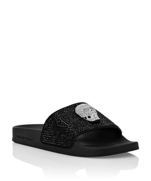 Verfraaid  Luxe aan het zwembad en ontspannen met deze rubberen slidersandalen met een suède enkelband versierd met strassteentjes en de juweelversie van de iconische Skull. Voorgevormd voetbed en rubberen glijzool.
