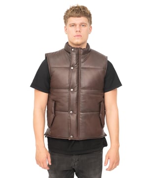 Dit gilet is gemaakt van ons premium volnerf nappaleer, wat resulteert in een gladde afwerking die mooi aansluit bij de gepolijste metalen drukknopen waarmee het jasje wordt vastgemaakt. We hebben twee schuine verticale klepzakken in de taille die een extra flair geven aan deze verder strakke voorkant en kunnen worden dichtgeknoopt voor veilige opslag. Deze jas is gemaakt in pufferstijl voor extra isolatie tijdens kouder weer en is verkrijgbaar in onze premium kleuren zwart, bruin en bruin. • Gemaakt van ultrazacht nappaleer • Twee verticale klepzakken in de taille • Korte opstaande kraag met knoop en knoopsluiting aan de voorkant