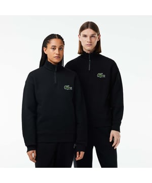 Unisex Lacoste Loose Fit High Neck Sweatshirt in Black. Finest materials, brand’s singular expertise. The perfect expression of Lacoste’s timeless wardrobe.- Loose fit is loose ease on body and sleeves, lower shoulders and armholes.- Half zipped sweatshirt in organic heavy French terry with big croc 80' on chest.- Unisexe.- Zipped high collar in shell fabric.- 7cm iconic original badge crocodile.- 3cm green crocodile at under middle back collar. Material: 100% Organic Cotton. Ref: SH0069031.