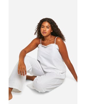 Chic pinstripe pattern for a classic look
        Comfortable cami top with delicate lace trim
        Wide-leg trousers for ultimate relaxation
        Adjustable spaghetti straps for a perfect fit
        Lightweight fabric ideal for year-round wear
    
    Indulge in the perfect blend of comfort and style with this charming plus-size pyjama set. The pinstripe pattern adds a touch of sophistication to your nighttime routine, whilst the soft fabric ensures a cosy night's sleep. The cami top features a flattering lace trim and adjustable straps, allowing you to customise the fit to your liking. Pair it with the wide-leg trousers for a relaxed silhouette that's perfect for lounging. Whether you're settling in for a movie night or enjoying a lazy weekend morning, this versatile set is your go-to choice. The lightweight fabric makes it suitable for all seasons, keeping you cool in summer and comfortably warm in winter. Embrace the effortless chic of this pyjama set and transform your nightwear collection.