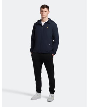 Perfect om naar de sportschool te gaan, de stad in te gaan of rustige dagen thuis, de Lyle & Scott Slim Sweat-broek is een loungewear-nietje. Deze herenjoggingbroek is gemaakt van 100% katoen voor maximaal comfort en heeft een elastische taille met trekkoord, geribbelde enkelmanchetten, zijzakken en de klassieke Lyle & Scott Golden Eagle. Verkrijgbaar in grote maten. Pasvorm: Slim
 Ontworpen om u een getailleerde pasvorm te geven die de lijnen van het lichaam beter volgt dan onze normaal gesneden kleding. Zit je tussen twee maten in, dan raden we je aan om de grotere maat te kopen.