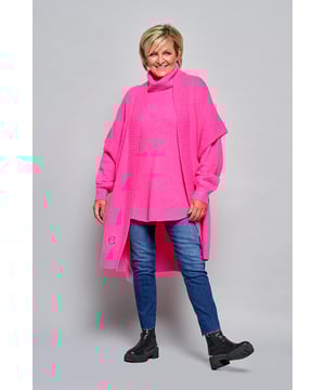Het Burnaby vest in een opvallende roze tint is perfect voor een elegante en comfortabele look. Dit vest is voorzien van een uniek borduursel dat een persoonlijk verhaal vertelt, geïnspireerd door Caroline’s tatoeage. De duifjes symboliseren eeuwige liefde. Het vest heeft een zachte sjaalkraag van ribstof, brede ribboorden, en korte, aangeknipte mouwen. De rechte pasvorm, die tot op de knie valt, biedt zowel stijl als comfort. Gemaakt van een mix van 30% polyester, 27% nylon, 25% acryl, 15% wol en 3% elastaan, is dit oversized vest licht, zacht en ademend, wat het geschikt maakt voor elk seizoen. De levendige roze kleur van het vest maakt het gemakkelijk te combineren met andere kledingstukken. Voor een vrouwelijke uitstraling kun je het vest dragen met de witte Winslow blouse. Het Burnaby vest, met korte mouwen en open draagstijl, is ideaal om te dragen over de Brampton trui voor een winterse look. Ontdek de veelzijdigheid en het stijlvolle karakter van deze combinaties.