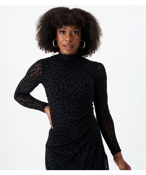 Geniet van luxe en verfijning met onze Black Animal Devore midi-jurk met hoge hals. Dit elegante exemplaar is voorzien van ingewikkelde dierendetails, waardoor je stijl naar nieuwe hoogten wordt getild. Met een hooggesloten design straal je een smaakvolle en exclusieve uitstraling uit. Omarm de fijnere dingen in het leven met deze prachtige jurk.