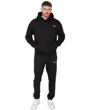 Presentamos el Conjunto de Chándal con Sudadera con Capucha Oversized Averè para Hombre de Enzo Milano, una mezcla perfecta de comodidad y estilo. Este set incluye una Sudadera con Capucha Oversized con un suave forro de felpa, un logotipo sutil en el pecho, un diseño audaz en la parte trasera y una capucha con botones a presión. Los Joggers de Corte Regular tienen una cintura elástica, cordones ajustables, bolsillos laterales y puños acanalados en los tobillos para un ajuste seguro. Ideal para relajarse o para salidas casuales, este chándal ofrece un estilo relajado y a la moda