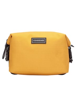 The Ellis Wash Bag, an essential cosmetic companion is made of RE-CONSIGNED outer fabric, produced from 100% recycled plastic bottles - Global Recycled Standard certified fabric. A double clip feature allows multi-functional use, enabling the bag to transform into 3 different designs depending on your needs. It’s all in the detail with a specialist waterproof zip providing easy access to the main compartment. The interior features our wipe clean microfibre lining with double slip pockets and a large central compartment for all your essential cosmetic needs. Features: , RE-CONSIGNED ripstop outer fabric made from 100% recycled plastic bottles - Global Recycled Standard certified fabric, 4 Plastic bottles saved from landfill in the production of this product, 4 Litre internal capacity, Water Resistant, Double clip feature which allows the bag to be styled 3 different ways, Waterproof zip top opening to main compartment, 2 Internal slip pockets, CONSIGNED seal of approval rubberised patch logo, RE-CONSIGNED seal of approval rubberised patch logo, CONSIGNED branded webbing, Microfibre easy wipe clean lining, Rubberised zip pullers, Small model Style Ref: 50527 MUSTARD