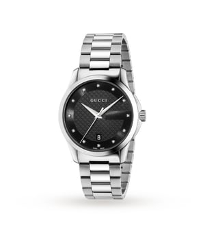 Met het tot in de perfectie gepolijste silhouet en diamanten details introduceert Gucci het G-Timeless Diamond Date-horloge, het ultieme luxe accessoire dat je nooit meer wilt afdoen. Het heeft dezelfde designflair als hun kleding en is te onderscheiden door de ronde kast van 38 mm en zorgvuldig vervaardigd uit hoogglanzend gepolijst en geborsteld roestvrij staal. Binnenin de kast heeft de zwarte wijzerplaat een subtiel diamanten schaakbordeffect in het midden en een ingetogen 'G'-logo langs de buitenrand. Aangevuld met twaalf met diamanten gezette indexen die schitteren als hij beweegt, staalkleurige, zwaardvormige uren- en minutenwijzers en een slanke secondewijzer. Een datumvenster bevindt zich op de 6-uurpositie, waardoor functionaliteit aan uw formulier wordt toegevoegd en u punctueel blijft in uw dagelijkse routine. Het iconische Gucci-logo waarborgt het kwaliteitsstempel en alles wordt beschermd door een saffierkristallen glazen kap. De ring, lugs en drie schakels zijn op elkaar afgestemd in gepolijst en geborsteld staal, het is gevuld met karakter en wordt vastgemaakt met een gesp voor een veilige en comfortabele pasvorm. Aangedreven door Zwitserse kwartstechnologie, is hij extreem nauwkeurig en heeft hij een waterdichtheid van 50 meter, ideaal voor dagelijks gebruik. De G-Timeless Date weerspiegelt de geest van luxe en houdt u op tijd en trendy, waardoor het de perfecte aanvulling is voor zowel 's avonds als overdag. Schitter helder en voeg diamanten toe aan je dagelijkse kleding met Gucci