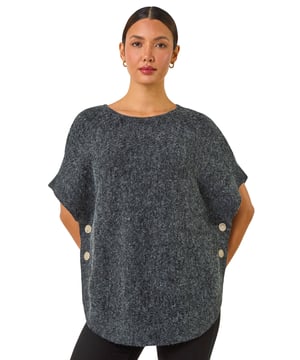 Contrast Roll Neck Button Knit Poncho from Roman. Indulge in comfort with our cosy knit poncho that is perfect for the cooler months. The roll neckline features a stylish contrast design while the side button details add a trendy touch. Crafted from a soft mix of knitted fabrics, this poncho is your ideal companion to beat the daily chill in style. Pair with faux leather pants and ankle boots for a complete Autumn Winter look!