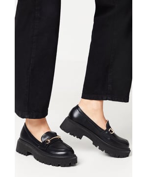 Faux leather loafers with a chunky sole for a bold, contemporary look
Snaffle detail across the vamp adds a touch of equestrian-inspired style
Slip-on design for effortless on-and-off wear
Flat heel between 0 and 2cm offers all-day comfort
Versatile silhouette to complement both casual and smart-casual ensembles

Exuding a modern, fashion-forward aesthetic, these faux leather loafers from Faith are a versatile choice for day-to-night dressing. The chunky sole lends a contemporary edge, while the snaffle detail across the vamp adds a hint of equestrian flair. Effortlessly slip them on with tailored trousers or a midi skirt for a polished yet relaxed look suitable for the office or weekend brunch. Alternatively, team them with a slip dress and denim jacket for an elevated evening ensemble.