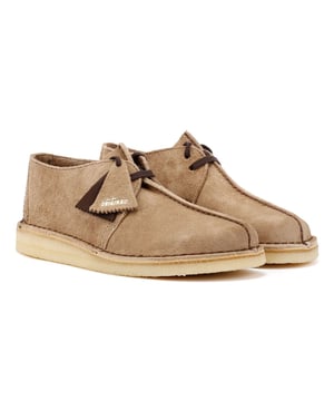 Erstmals in den 1970er Jahren eingeführt, zeichnen sich die Wüstentrekking-Schuhe von Clarks durch einen kontrastierenden Akzent an der Ferse und eine zentrale Naht aus. Hergestellt aus hochwertigen Materialien, verfügen sie über eine Schnürung und eine markante kontrastierende Crepe-Sohle.