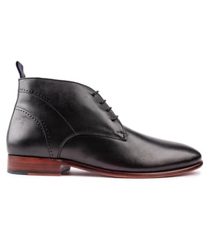 Estos botines negros con cordones SOLE Drayton para hombre, con una parte superior de cuero de primera calidad, cuentan con ojales ciegos, cordones delgados y un elegante diseño de perforaciones con costuras, que brindan elegancia adicional. Estas elegantes botas Chukka tienen forro y calcetín de cuero, suela de cuero repujada, marca del diseñador y son exclusivas de SOLE.