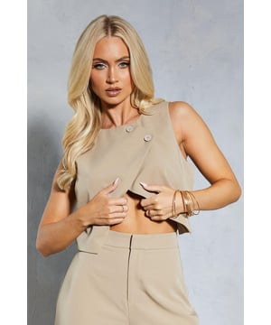 Asymmetric design with double button closure
        Collarless neckline for a sleek look
        Cropped length to accentuate the waistline
        Boxy fit for a contemporary silhouette
        Versatile piece suitable for various casual occasions
    
    Make a bold statement with this eye-catching asymmetric double button waistcoat from MissPap. The unique design features a collarless neckline and a cropped length, perfect for showcasing your midriff and creating a daring look. The boxy fit adds a modern touch to this versatile piece, making it ideal for those who love to stand out from the crowd. Style it with high-waisted trousers and strappy heels for a night out with friends, or pair it with wide-leg trousers and trainers for a more relaxed daytime ensemble. This waistcoat is a must-have for the fashion-forward individual who isn't afraid to experiment with their style. Whether you're heading to a casual gathering or a family event, this piece will ensure all eyes are on you.