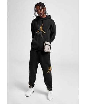 Nike Heren Jordan Baseline HBR Overhead Trainingspak. - - . Deze regular-fit hoodie in een zwarte kleurstelling is gemaakt van een fleecestof met een mix van katoen en poly voor comfort en warmte de hele dag door. - Het heeft een pullover-ontwerp voor een klassieke look, een capuchon met trekkoord zodat je je bedekking kunt aanpassen, en rekbare geribde boorden om de pasvorm te optimaliseren. - - .  Met een kangoeroezak voor opbergruimte en afgewerkt met het iconische Jumpman Gold-logo op de borst. - - .  De regular-fit joggers zijn gemaakt van een katoen poly fleece stof die zacht en warm is om je comfortabel warm te dragen. - - .  Ze hebben een elastische tailleband voor een ontspannen gevoel, omgeslagen enkels zodat je je kicksen kunt strekken, met steekzakken en een achterzak voor opslag. - - .   Afgewerkt met het Jumpman-logo op het been.
