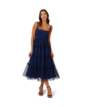 Modern fabric mixes make this classic fit and flare dress a sweet look. This midi dress features a fitted bodice with tank straps, a square neckline, and a tiered skirt. Fully lined, the bodice is crafted from a knit fabrication while the skirt is overlaid in mesh for added sweep. Pockets and a square back with centre zip closure complete this delightful party dress. Styled with nude heels and sparkling accessories, this midi dress is a timeless look from wedding guest duty to cocktail parties
