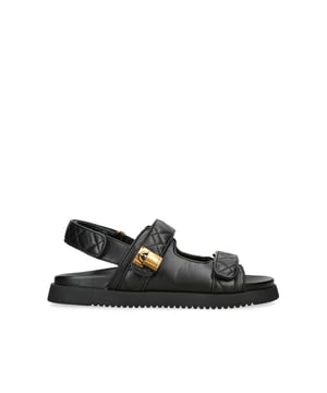 This Kurt Geiger Brixton Lock Sandal features a black upper with two straps across the foot. Each strap features a quilt design and there is an antique brass branded padlock charm on the one. Sole height: 3cm.