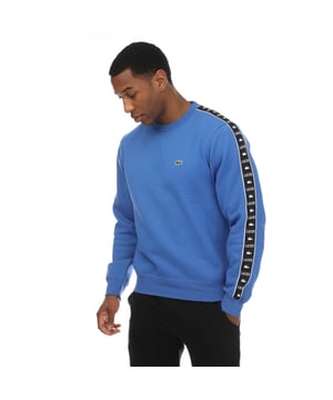 Mens Lacoste Logo Stripe Jogger Sweatshirt in blue.- Ribbed crewneck.- Elasticated cuffs and hem.- Embroidered logo on the chest and a logo pattern down both sleeves.- Classic fit.- Shell Fabric: 80% Cotton  20% Polyester. Rib edge: 98% Cotton  2% Elastane.- Ref: SH749200IXV
