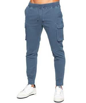 Pantalones cargo Enzo para hombre. Ajuste regular, pierna recta, lavado con enzimas. Diseño de 5 bolsillos. 2 bolsillos laterales, 2 bolsillos cargo con cierre de velcro. Bolsillo trasero único. Cintura elástica con cordón ajustable.