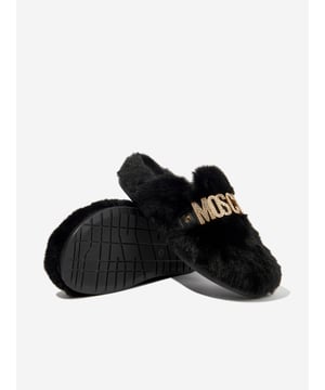 Introducing the Girls Faux Fur Logo Slippers in Black by Moschino Shoes, a high-end designer product from Italy, a captivating blend of luxury and comfort essential for your little girl's collection. Here are the key features that make it an exceptional piece:  Made in Italy: Meticulously crafted with superior attention to detail and quality, guarantees resilience and wear longevity.  Chic Design: The distinctive Moschino logo embedded on plush faux fur accentuates elegance and trend. Ultimate Comfort: Produced using premium materials, these slippers deliver unparalleled comfort during your girl's casual moments. Revamp your little girl's collection with these eye-catching Faux Fur Logo Slippers in black by Moschino Shoes. Order today and let your young one stride in style!