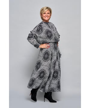 De Mitton printjurk uit de nieuwe collectie van Caroline Tensen is perfect voor het komende seizoen. Met een getailleerde pasvorm en een wijde onderkant biedt deze jurk een stijlvolle en casual uitstraling. De jurk heeft een opvallende bohemian stippenprint met unieke geometrische bloemen in zwart en wit. Deze lange jurk is voorzien van licht ballonvormige mouwen die eindigen in een strakke boord met bijpassende knoopjes bij de polsen en heeft een elegante V-hals. Het getailleerde ontwerp zorgt voor een comfortabel draaggevoel. De jurk heeft een opstaand boordje en een gestoffeerde knoopsluiting voor een nette afwerking. Combineer 'm in de avond met het leren Senia jasje en stoere laarzen. Een absolute must-have die het hele jaar door gedragen kan worden..!