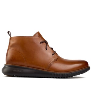 Experimente la comodidad de una nube con las botas Zerogrand Chukka de Cole Haan. Estas botas, confeccionadas en un rico cuero color canela con una elegante silueta Chukka, cuentan con la reconocida tecnología de suela Zerogrand de amortiguación de Cole Haan para pisadas ligeras y un uso cómodo. Las suelas de goma deportivas lo llevan sin esfuerzo, mientras que la presilla del talón, los cordones finos y el diseño elegante agregan características refinadas. Acentuadas por la marca distintiva de Cole Haan, las botas Zerogrand Chukka son una adición ideal a cualquier guardarropa moderno.