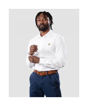 Perfect voor zowel formele als informele gelegenheden, het Lyle & Scott slim fit poplin overhemd is het hele jaar door onmisbaar. De perfecte manier om zachte kleuren en getailleerde pasvormen in je garderobe te introduceren, dit overhemd kan worden gecombineerd met jeans en chino's of als laagje met een T-shirt. Gemaakt van een zachte maar beweeglijke mix van katoen en elastaan ​​en compleet met slimme kraag, katoenen manchetten, detailstiksels en kenmerkende Golden Eagle. Pasvorm: Slim
 Ontworpen om je een getailleerde pasvorm te geven die de lijnen van het lichaam beter volgt dan onze reguliere snit kleding. Zit je tussen twee maten in, dan raden we je aan om de grotere maat te kopen.